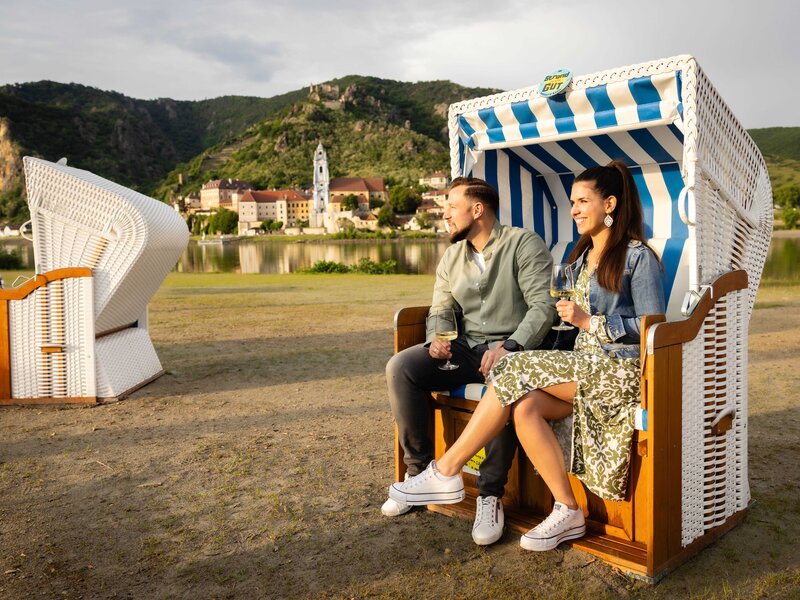 Gäste in Strandkörben mit Dürnstein im Hintergrund