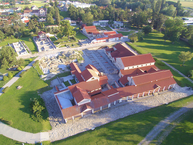 Luftaufnahme von den Ausgrabungen der Römerstadt Carnuntum, im Bild sieht man zum Beispiel die Römische Therme oder die villa urbana. Auch eine gepflasterte, römische Straße ist zu erkennen.